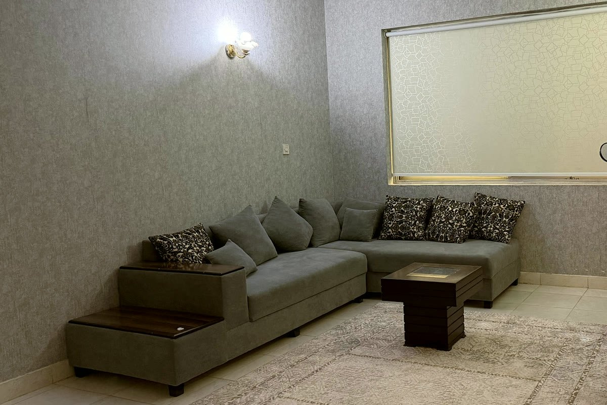 A quiet seating area with a long sofa and a rug