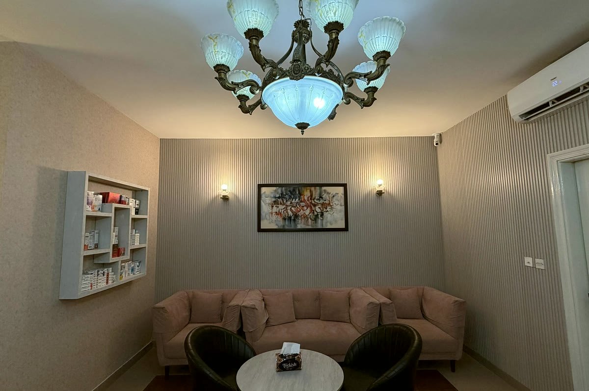 The waiting area, a sofa beneath framed artwork